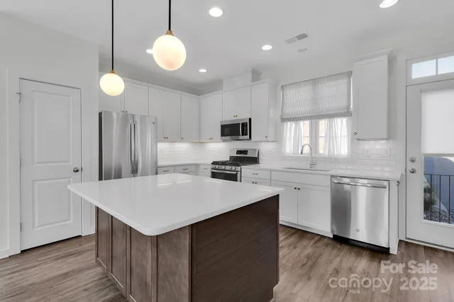a kitchen with white cabinets and stainless steel appliances