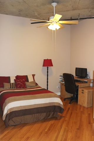 933 West Van Buren Street, Unit 321 Chicago, IL 60607 - Photo 10 of 18 a bedroom with a bed and a chandelier