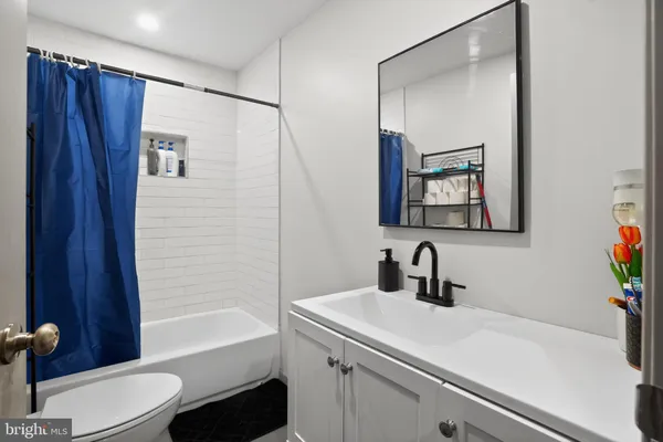 a bathroom with a sink a toilet a shower curtain and a mirror