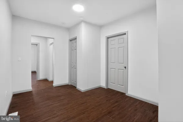 an empty room with wooden floor & closet area