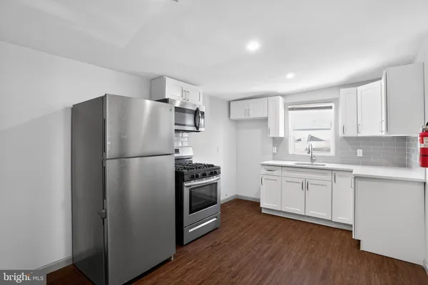 a kitchen with a refrigerator sink and cabinets