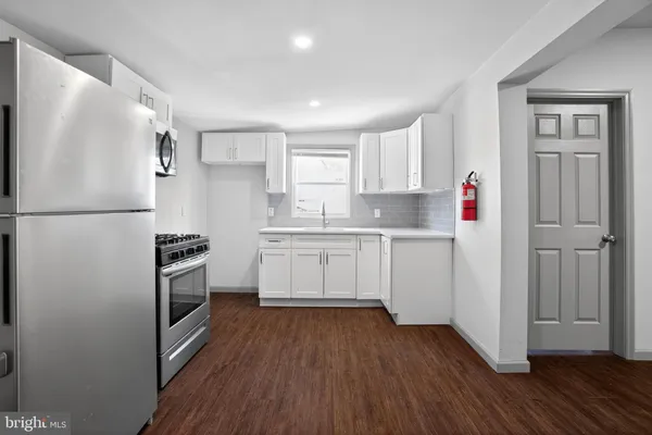 a kitchen with white cabinets and white appliances
