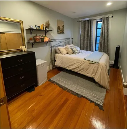 a bedroom with a bed and dresser with mirror