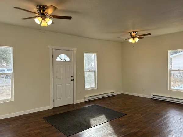 a view of a room with a window ceiling fan and wooden floor