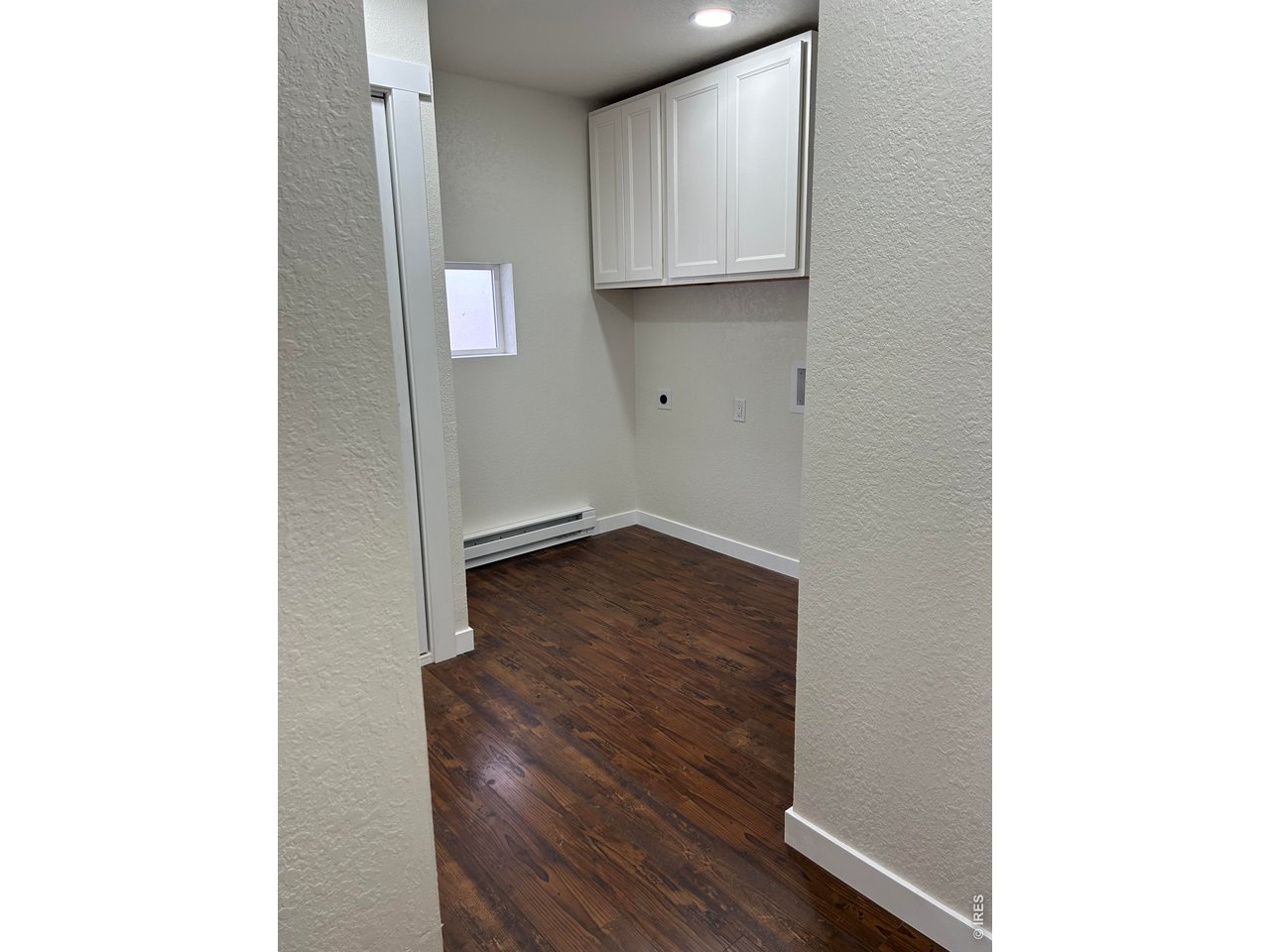 809 Warren Street Weldona, CO 80653 - Photo 9 of 19 a view of an empty room with wooden floor