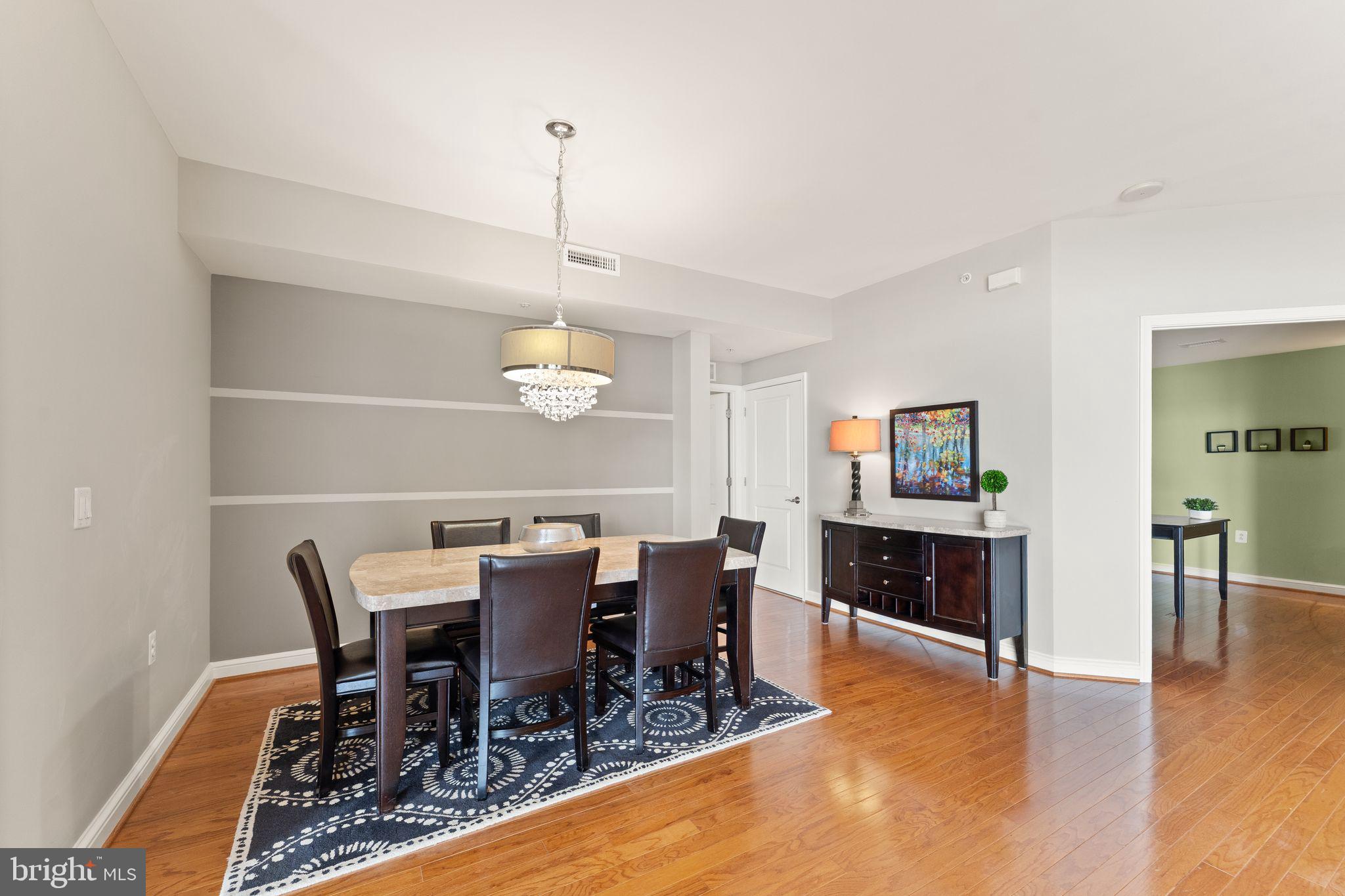 11990 Market Street, Unit 701 Reston, VA 20190 - Photo 19 of 93 a view of a dining room with furniture a chandelier and wooden floor