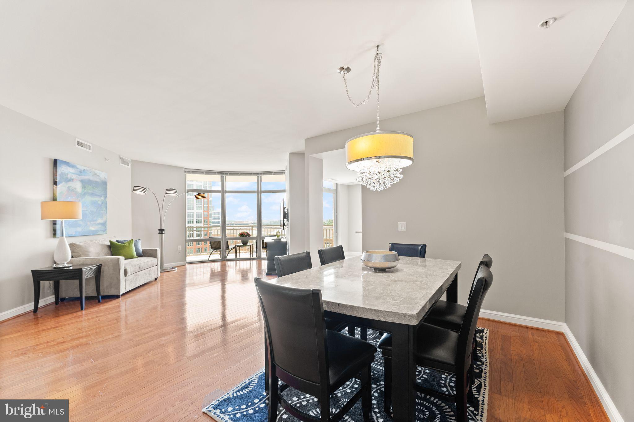 11990 Market Street, Unit 701 Reston, VA 20190 - Photo 21 of 93 a dining room with furniture a chandelier and wooden floor