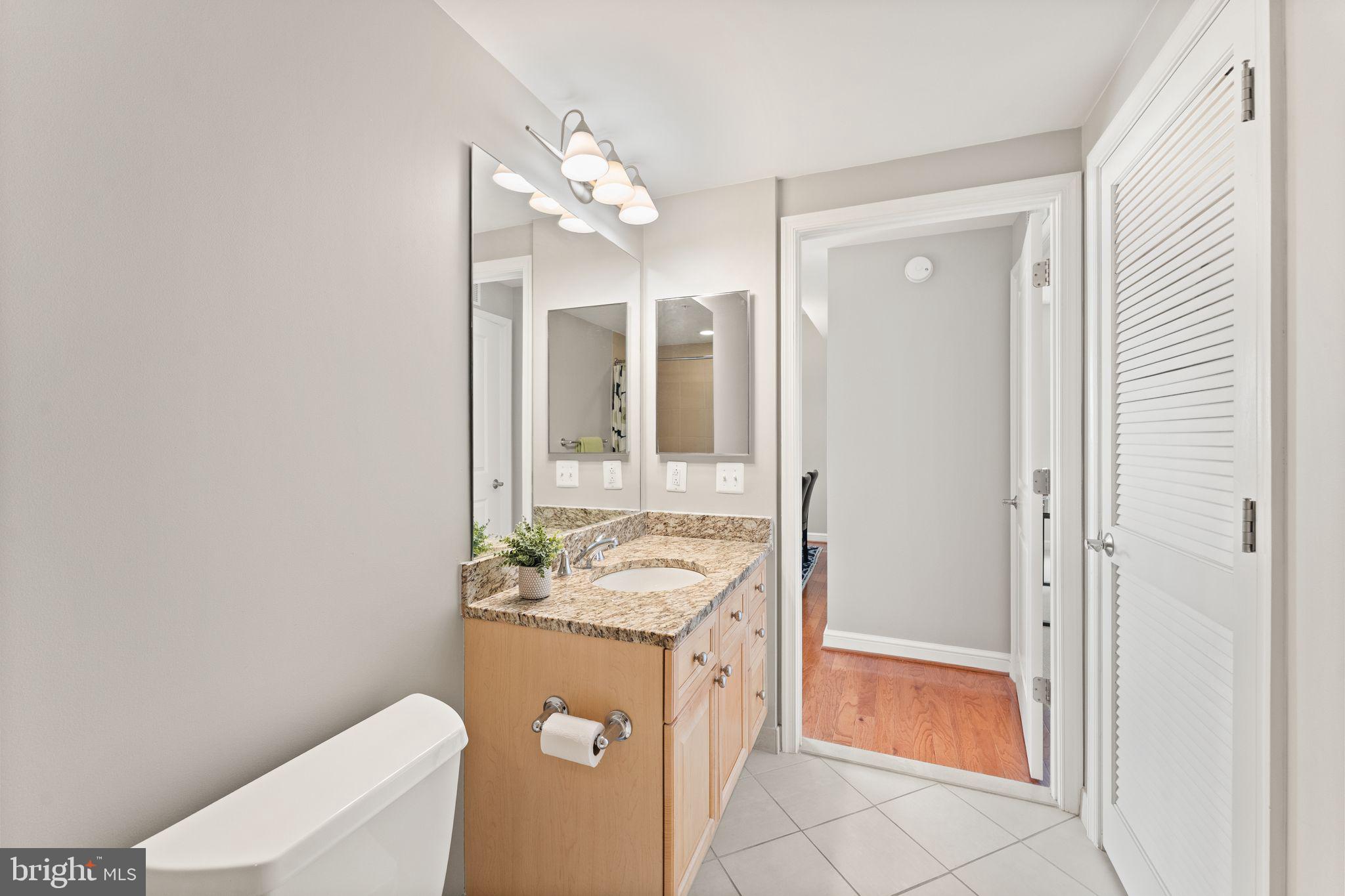 11990 Market Street, Unit 701 Reston, VA 20190 - Photo 25 of 93 a bathroom with a granite countertop sink and a mirror