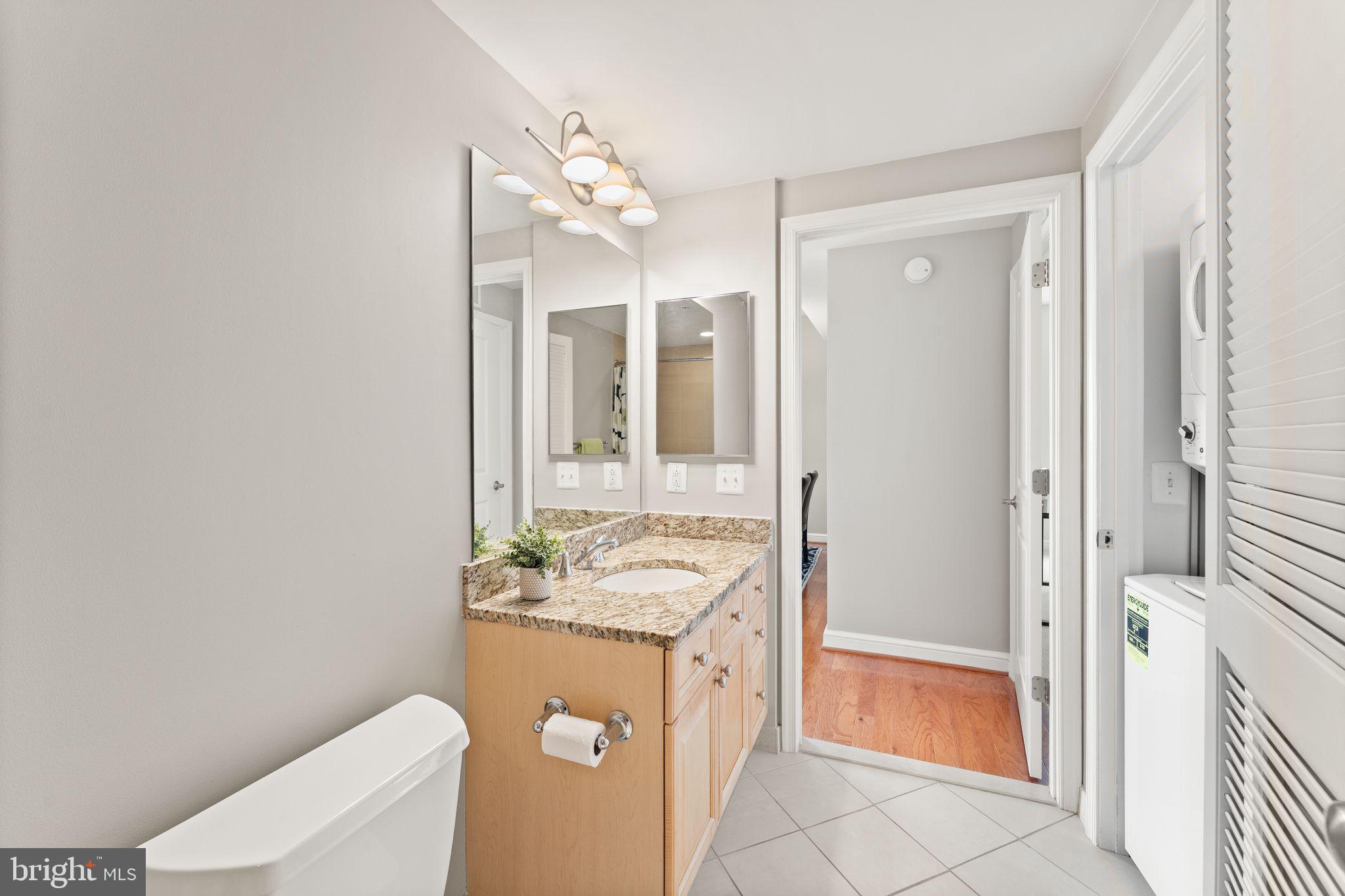 11990 Market Street, Unit 701 Reston, VA 20190 - Photo 26 of 93 a bathroom with a granite countertop sink and a mirror