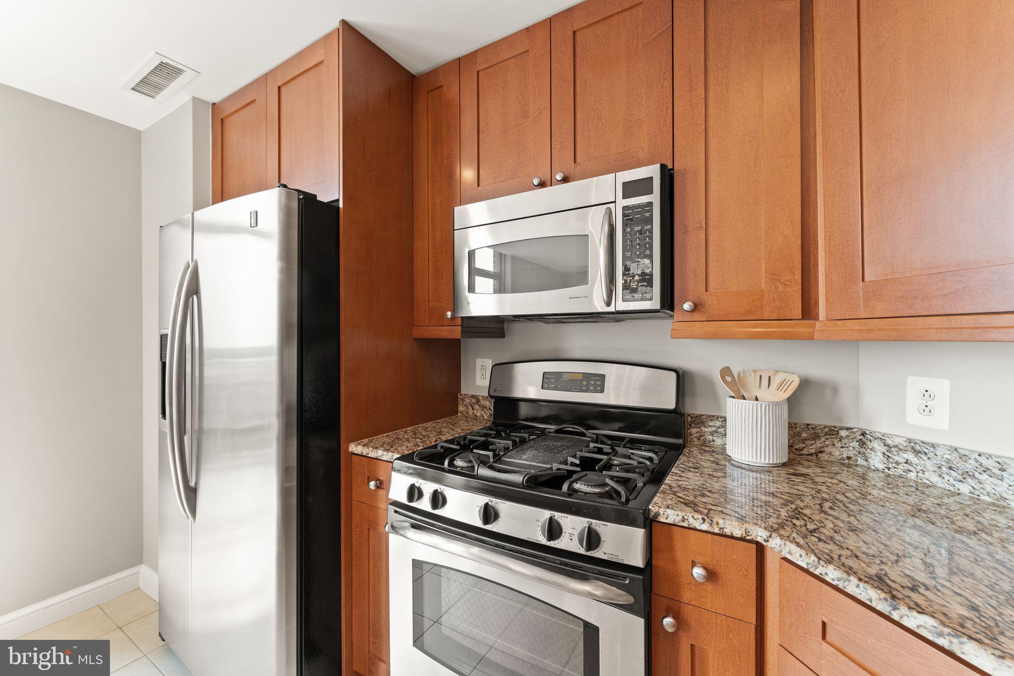 11990 Market Street, Unit 701 Reston, VA 20190 - Photo 31 of 93 a kitchen with stainless steel appliances granite countertop a refrigerator stove and microwave