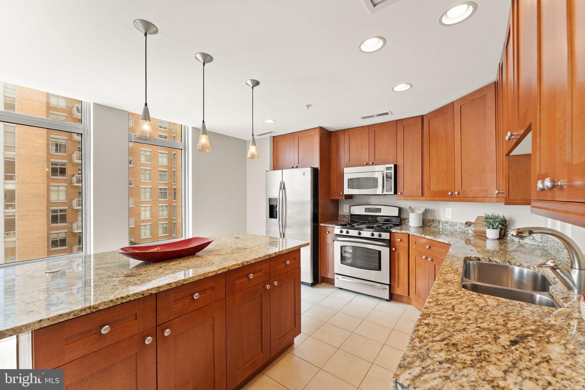 11990 Market Street, Unit 701 Reston, VA 20190 - Photo 33 of 93 a kitchen with stainless steel appliances granite countertop a sink a stove and a refrigerator