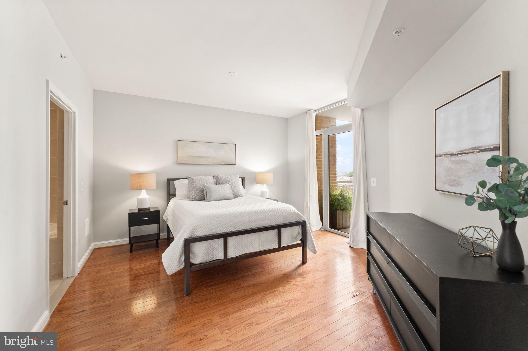 11990 Market Street, Unit 701 Reston, VA 20190 - Photo 34 of 93 a spacious bedroom with a bed and a potted plant on the dresser