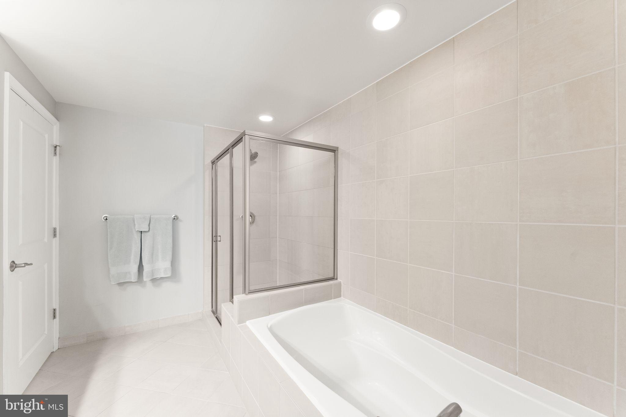 11990 Market Street, Unit 701 Reston, VA 20190 - Photo 39 of 93 a bathroom with a shower and a tub