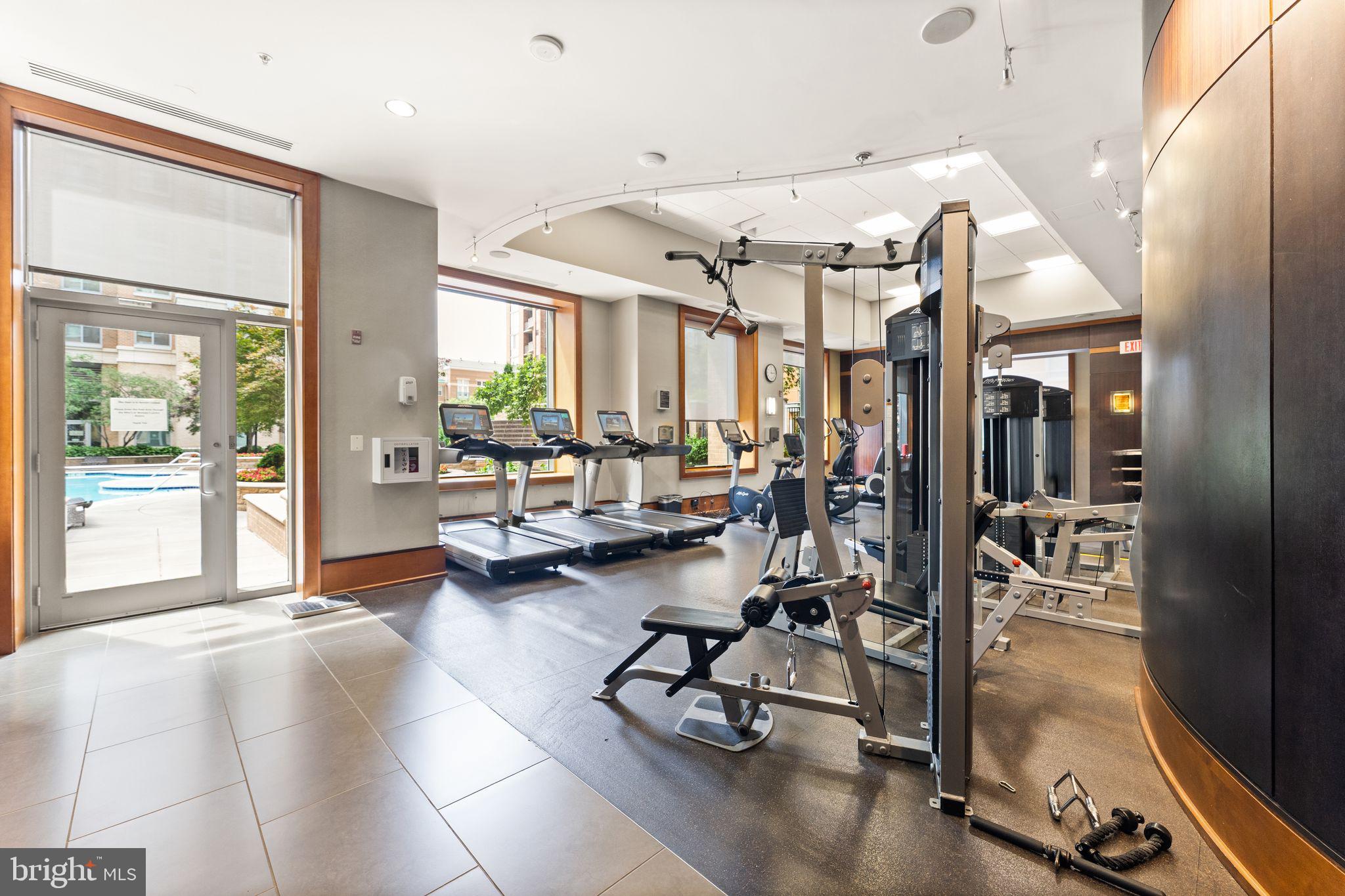 11990 Market Street, Unit 701 Reston, VA 20190 - Photo 50 of 93 a living room with lots of gym equipment and a large window