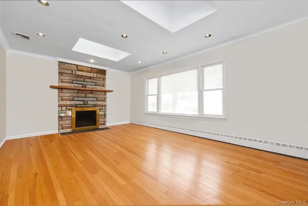 a view of an empty room with a fireplace and a window