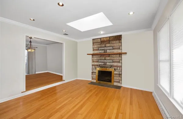 a view of empty room with wooden floor and fireplace
