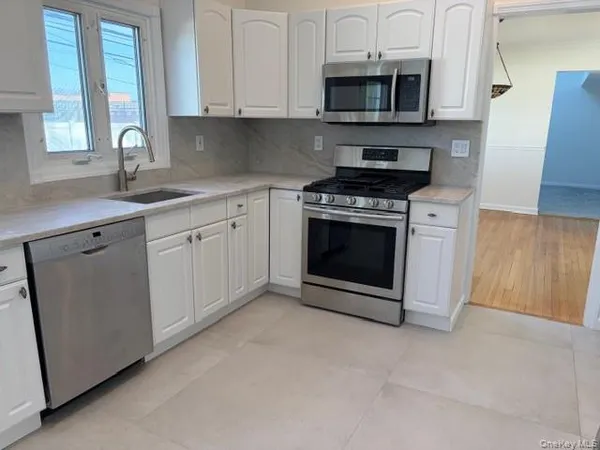 a kitchen with stainless steel appliances granite countertop a stove a microwave and a sink