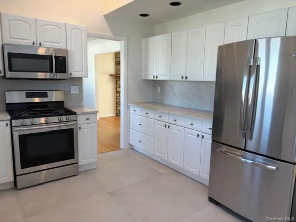 a kitchen with white cabinets and stainless steel appliances