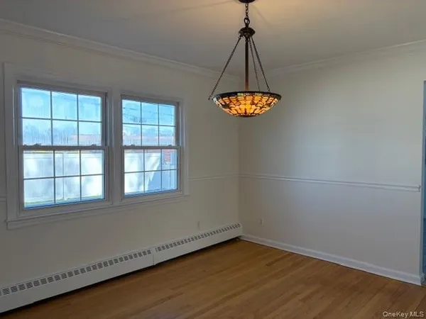 an empty room with a window and chandelier