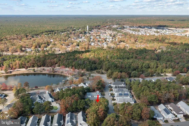 an aerial view of a house with a yard and a large tree