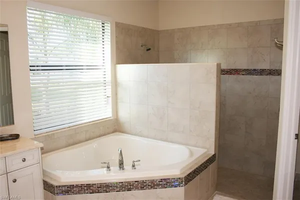 a bath tub sitting in a bathroom next to a window