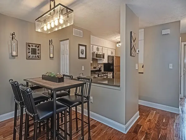 a view of a dining room with furniture a chandelier and wooden floor