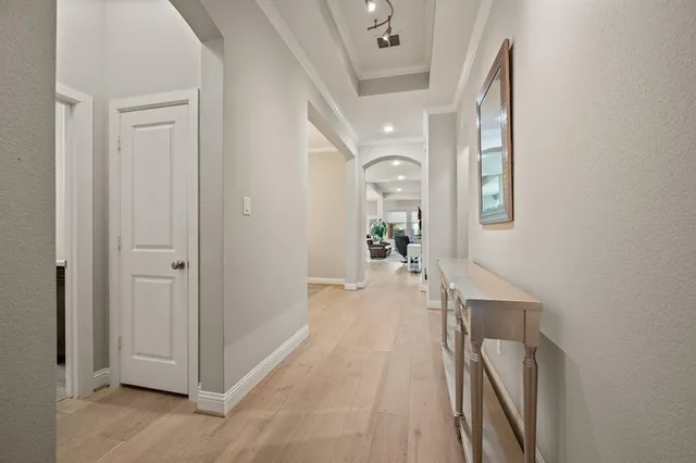a view of a hallway with wooden floor and a living room