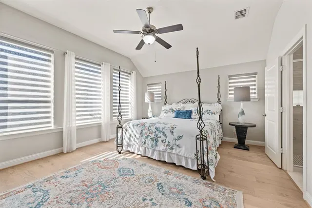 a bedroom with a large bed and a chandelier fan