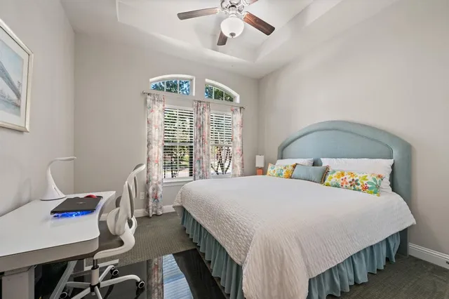 a bedroom with a bed a chandelier and a window