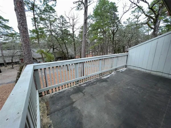 a view of a balcony with wooden fence and floor