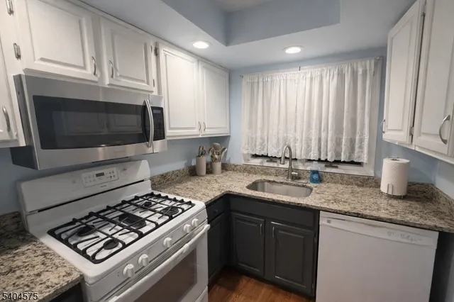a kitchen with stainless steel appliances granite countertop a sink stove top oven and microwave