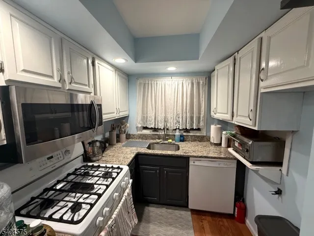 a kitchen with sink a stove and cabinets