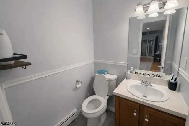 a bathroom with a granite countertop toilet sink and mirror