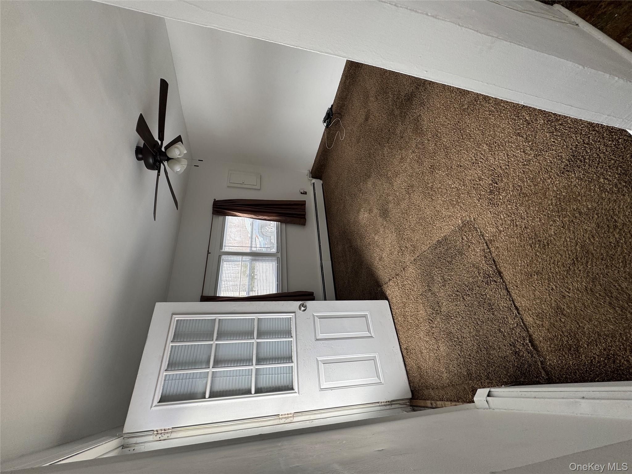 523 Fostertown Road Newburgh, NY 12550 - Photo 2 of 15 Carpeted empty room featuring a baseboard heating unit and a ceiling fan