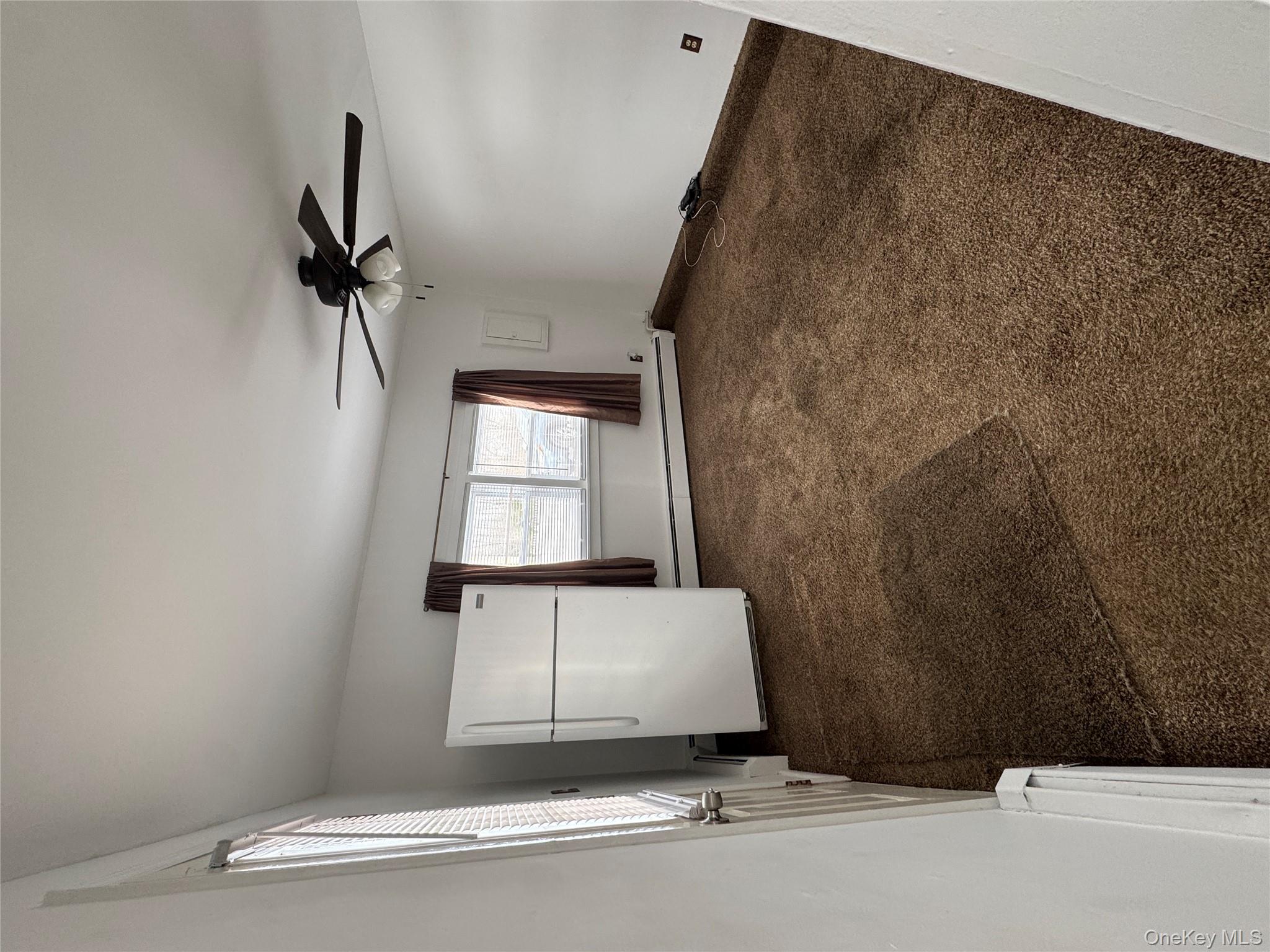 523 Fostertown Road Newburgh, NY 12550 - Photo 4 of 15 Carpeted empty room with a baseboard heating unit and ceiling fan