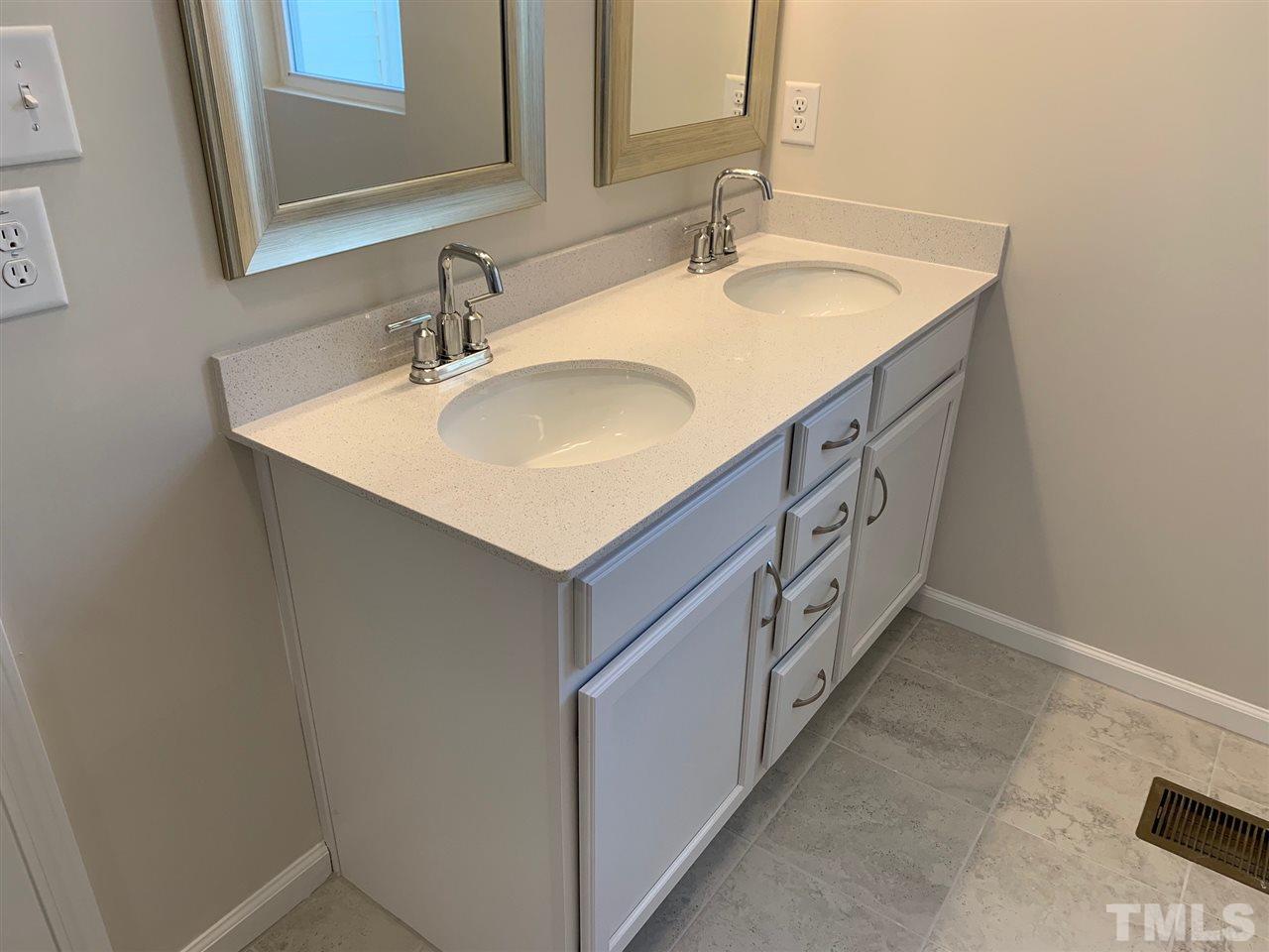 6108 Beale Loop, Unit 101 Raleigh, NC 27616 - Photo 13 of 30 a bathroom with 2 sink and a mirror