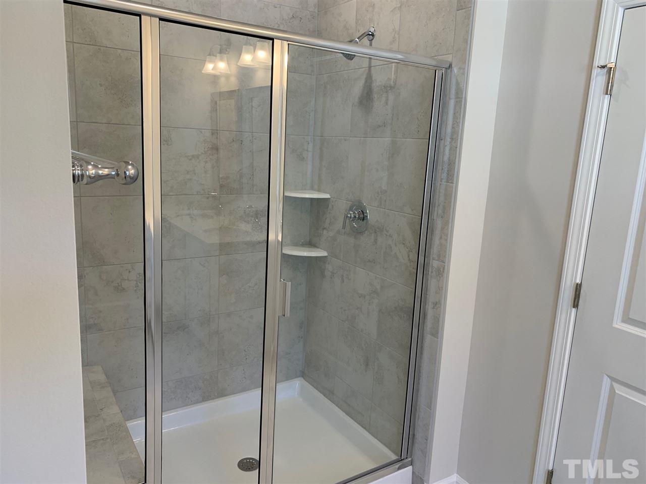 6108 Beale Loop, Unit 101 Raleigh, NC 27616 - Photo 14 of 30 a bathroom with a glass shower door