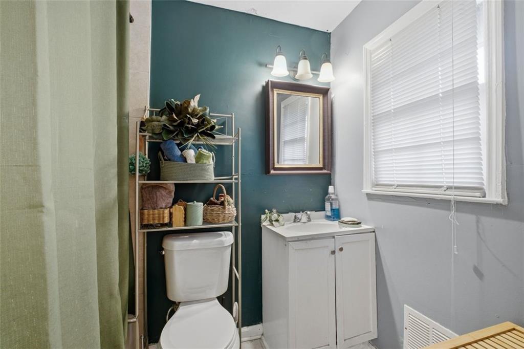957 Rowland Road Stone Mountain, GA 30083 - Photo 27 of 36 a bathroom with a toilet sink and mirror