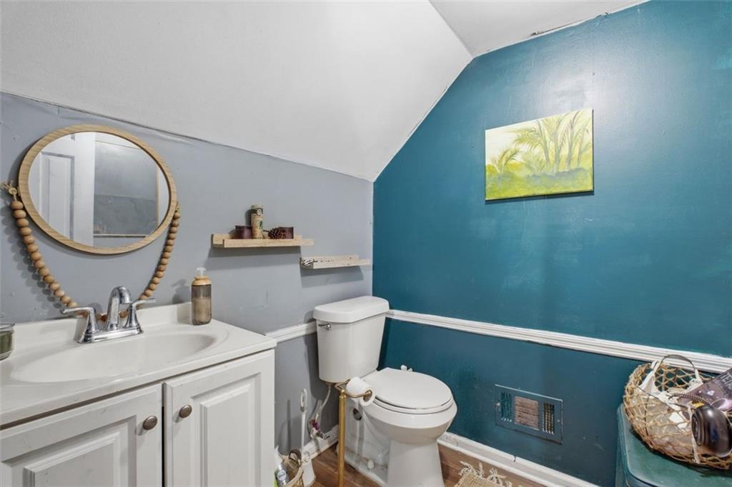 957 Rowland Road Stone Mountain, GA 30083 - Photo 30 of 36 a bathroom with a toilet a sink and mirror