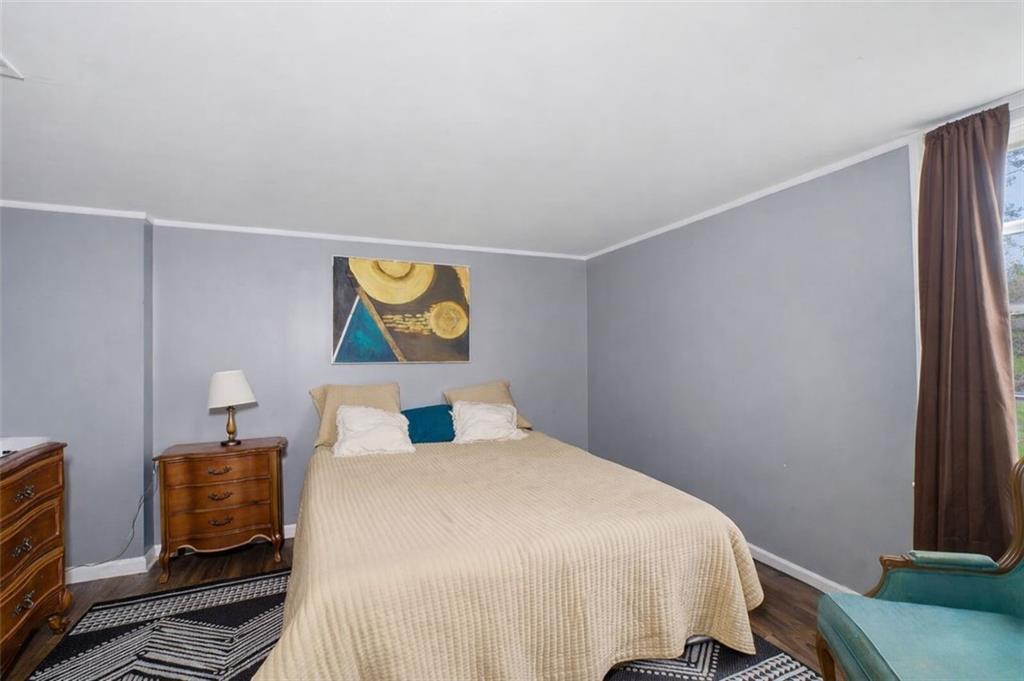 957 Rowland Road Stone Mountain, GA 30083 - Photo 33 of 36 a bedroom with a bed and wooden floor