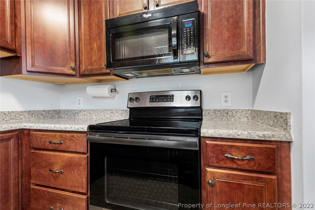 228 Overton Road Raeford, NC 28376 - Photo 11 of 23 a kitchen with granite countertop a stove top oven microwave and cabinets