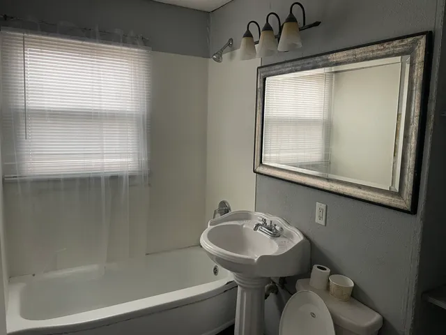 a bathroom with a sink toilet and a mirror