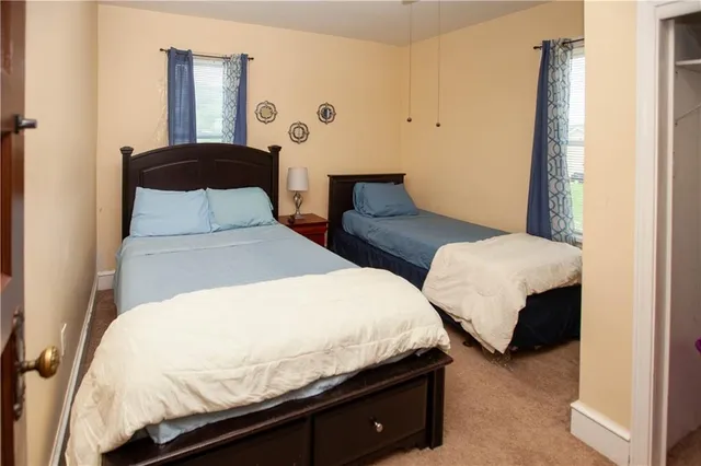 a bedroom with two beds and painting on the wall