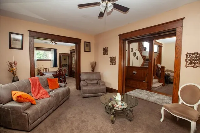 a living room with furniture kitchen view and a large window