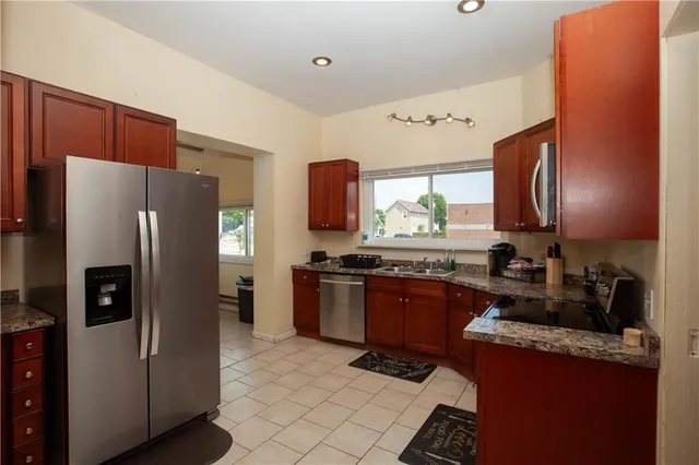 a kitchen with granite countertop stainless steel appliances and wooden cabinets