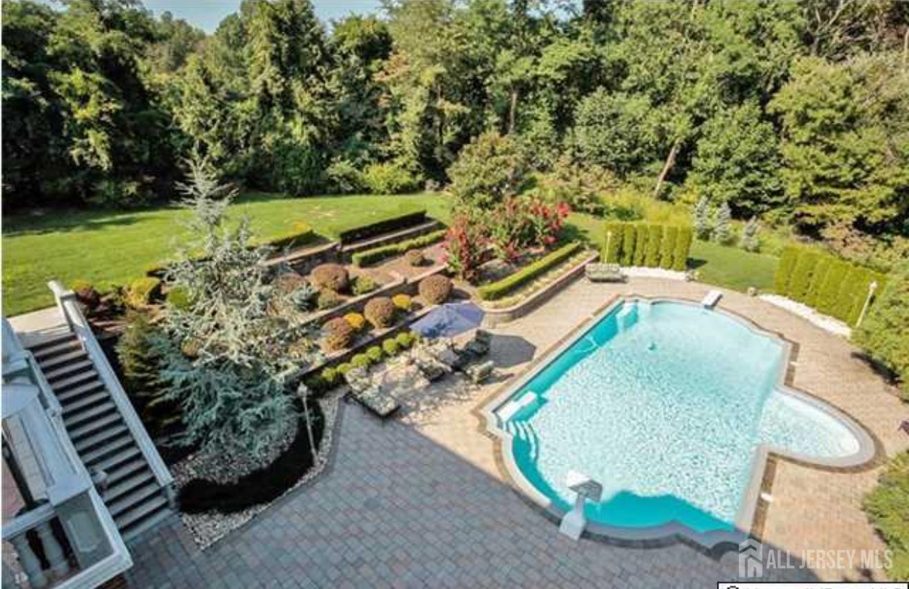 34 Line Road Holmdel, NJ 07733 - Photo 32 of 35 a view of a backyard with lawn chairs and a swimming pool