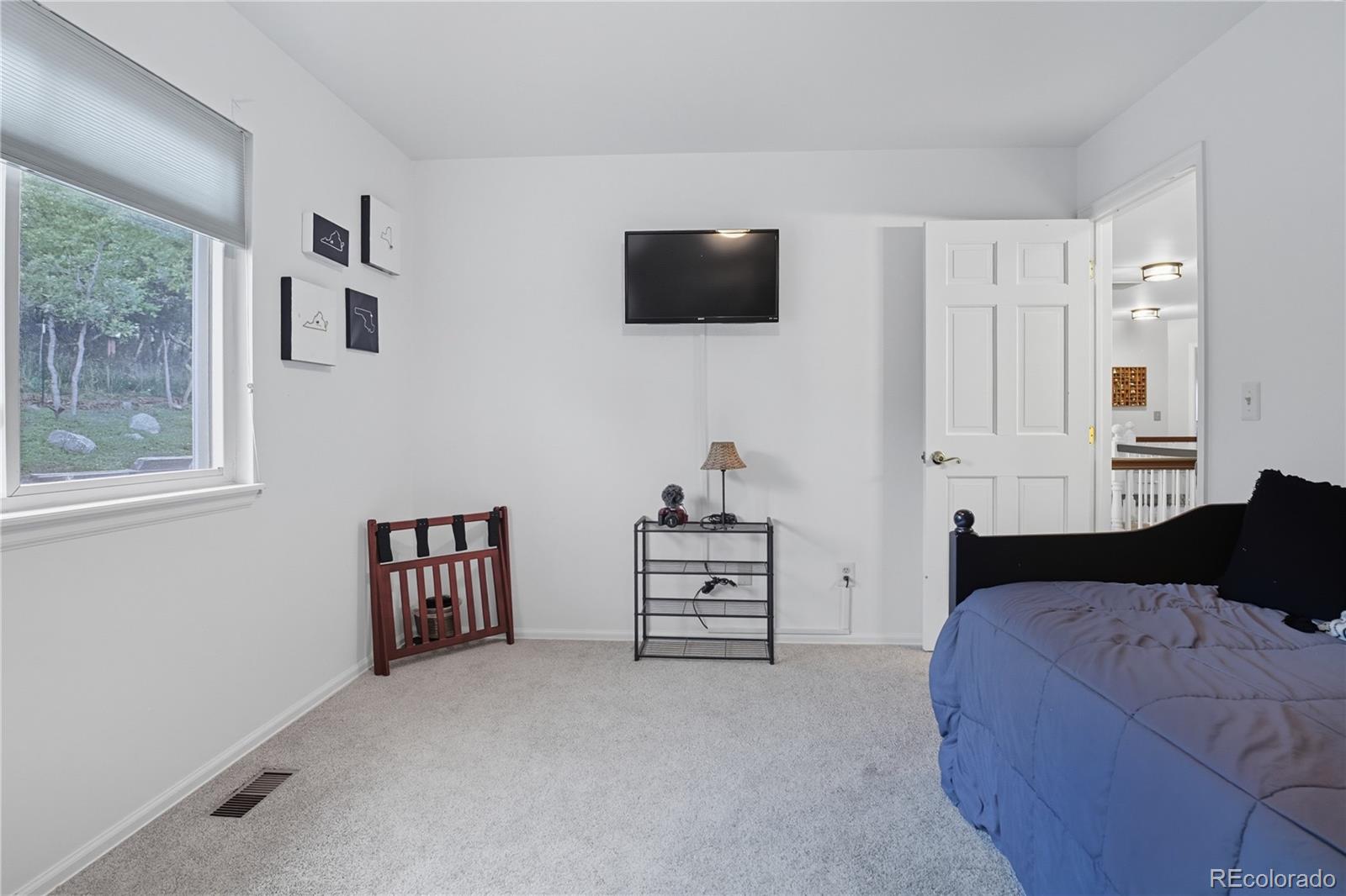 35 Ravenglass Way Colorado Springs, CO 80906 - Photo 34 of 45 a bedroom with a bed and a flat screen tv