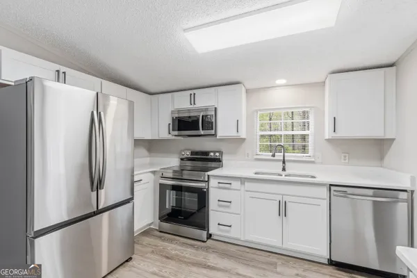 a kitchen with stainless steel appliances a refrigerator stove microwave and sink