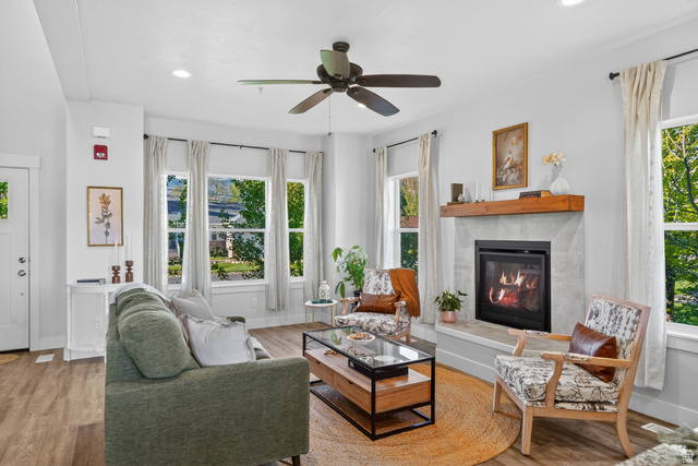 681 Island Road Morgan, UT 84050 - Photo 2 of 49 Living area featuring a modern fireplace with a substantial wood mantel, surrounded by multiple windows