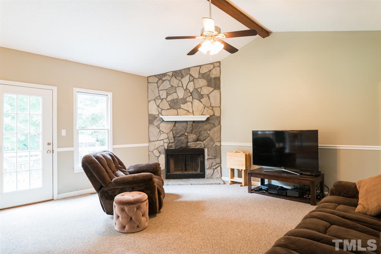 6016 Shadow Moss Circle Raleigh, NC 27603 - Photo 3 of 16 a living room with furniture a flat screen tv and a fireplace